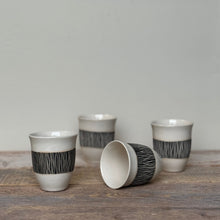 Load image into Gallery viewer, Set of ceramic cups with black and white patterns on a wooden surface.